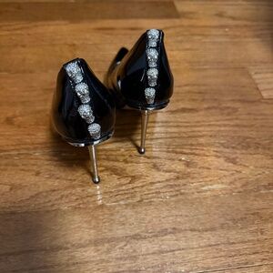Patent leather black heels with a silver heel.
